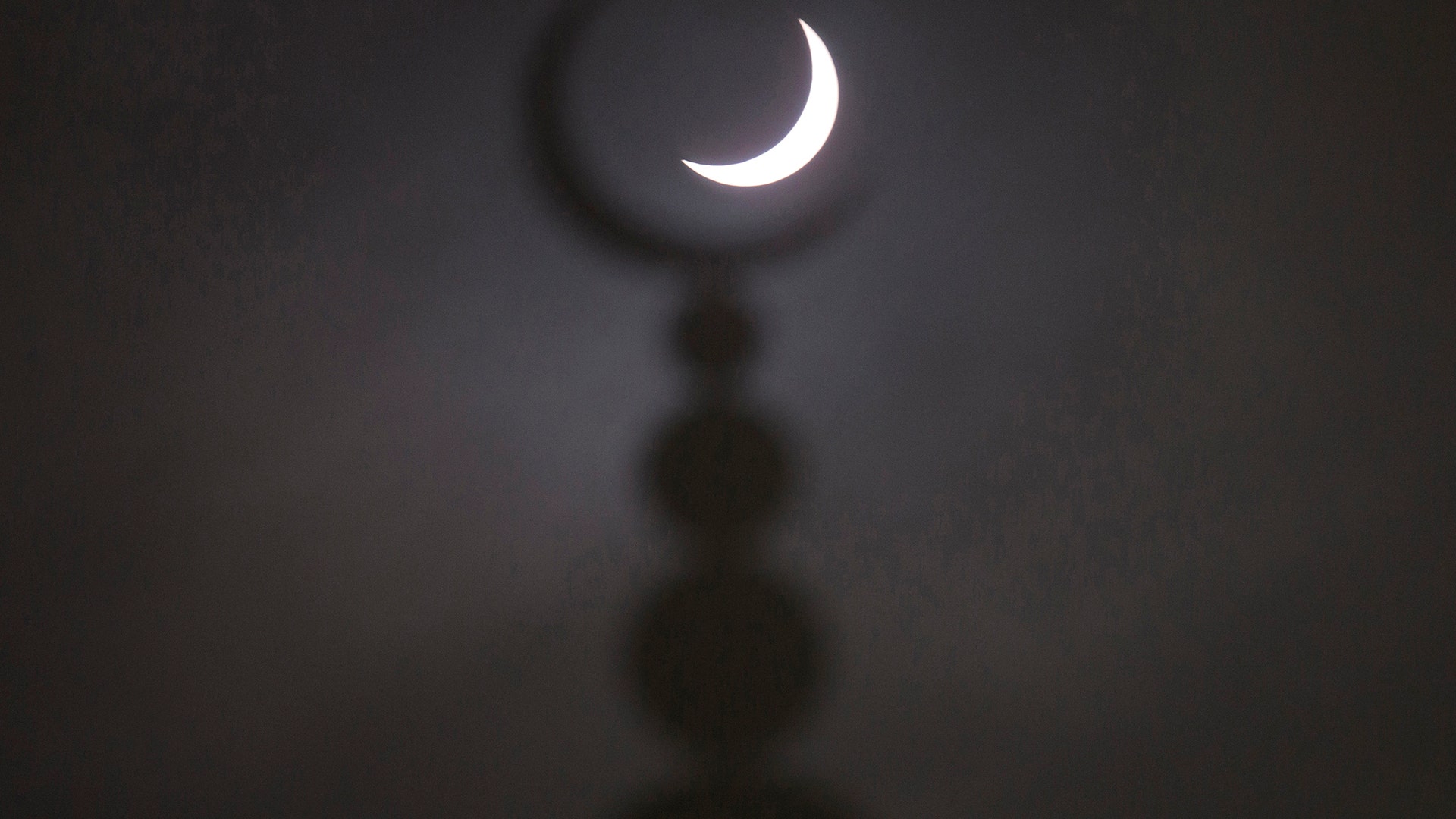 A partial solar eclipse is seen above a mosque in Oxford, England, March 20, 2015