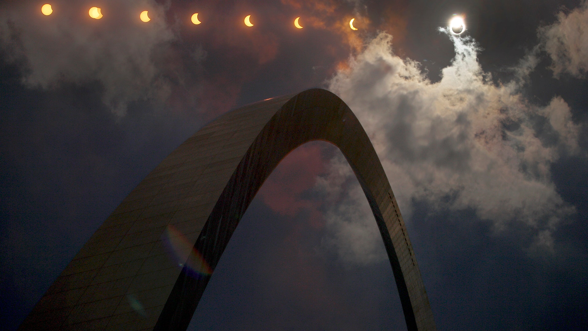 Multiple exposure photograph of the phases of a partial solar eclipse over the Gateway Arch in St. Louis