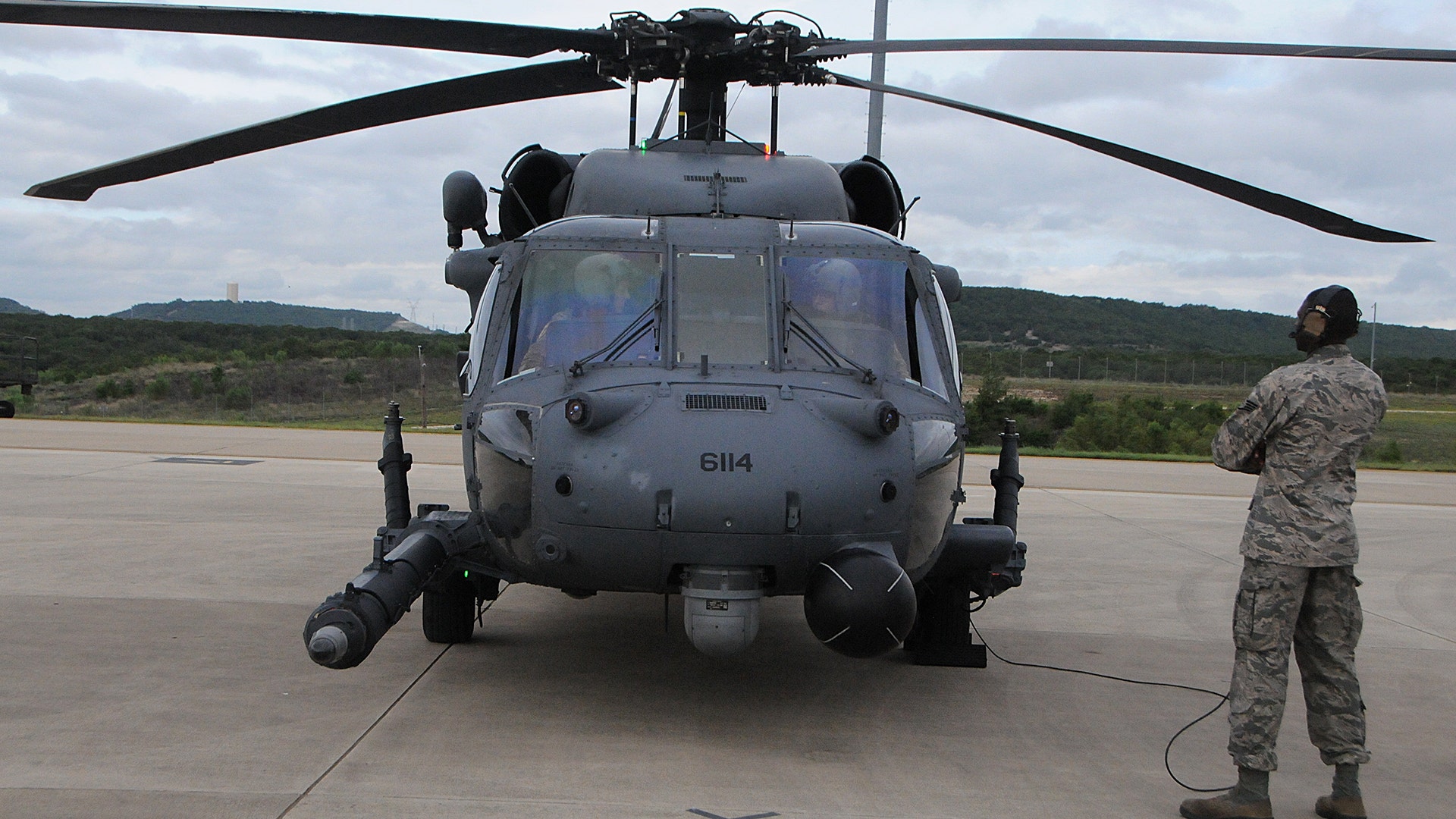 A crew chief watches aircrews of the 101st Rescue Squadron during HH-60 Pavehawk Helicopter pre-flight checks