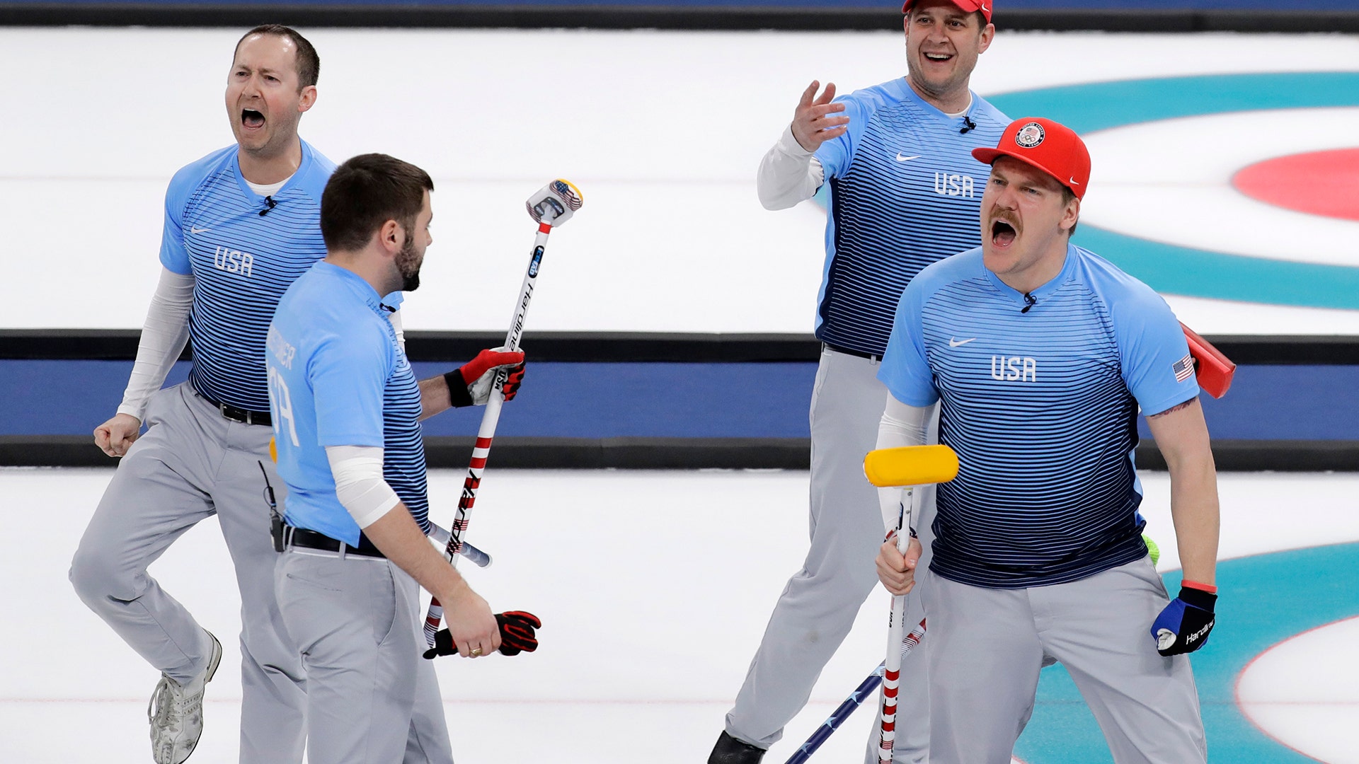 United States' team members celebrate defeating Canada during their men's curling semi-final match at the 2018 Winter Olympics