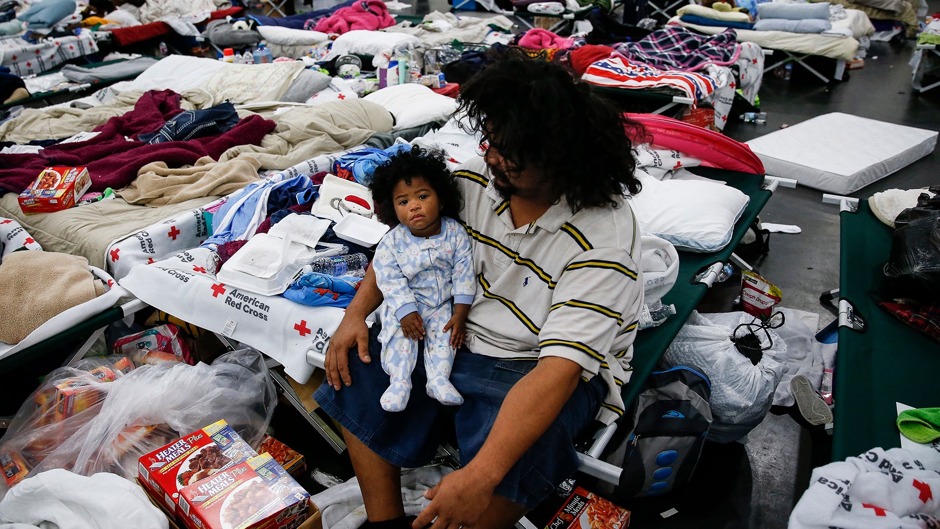 Edgar Molina holds his one-year-old daughter, Miracle Marie Molina, at the George R. Brown Convention Center in Houston, Wednesday