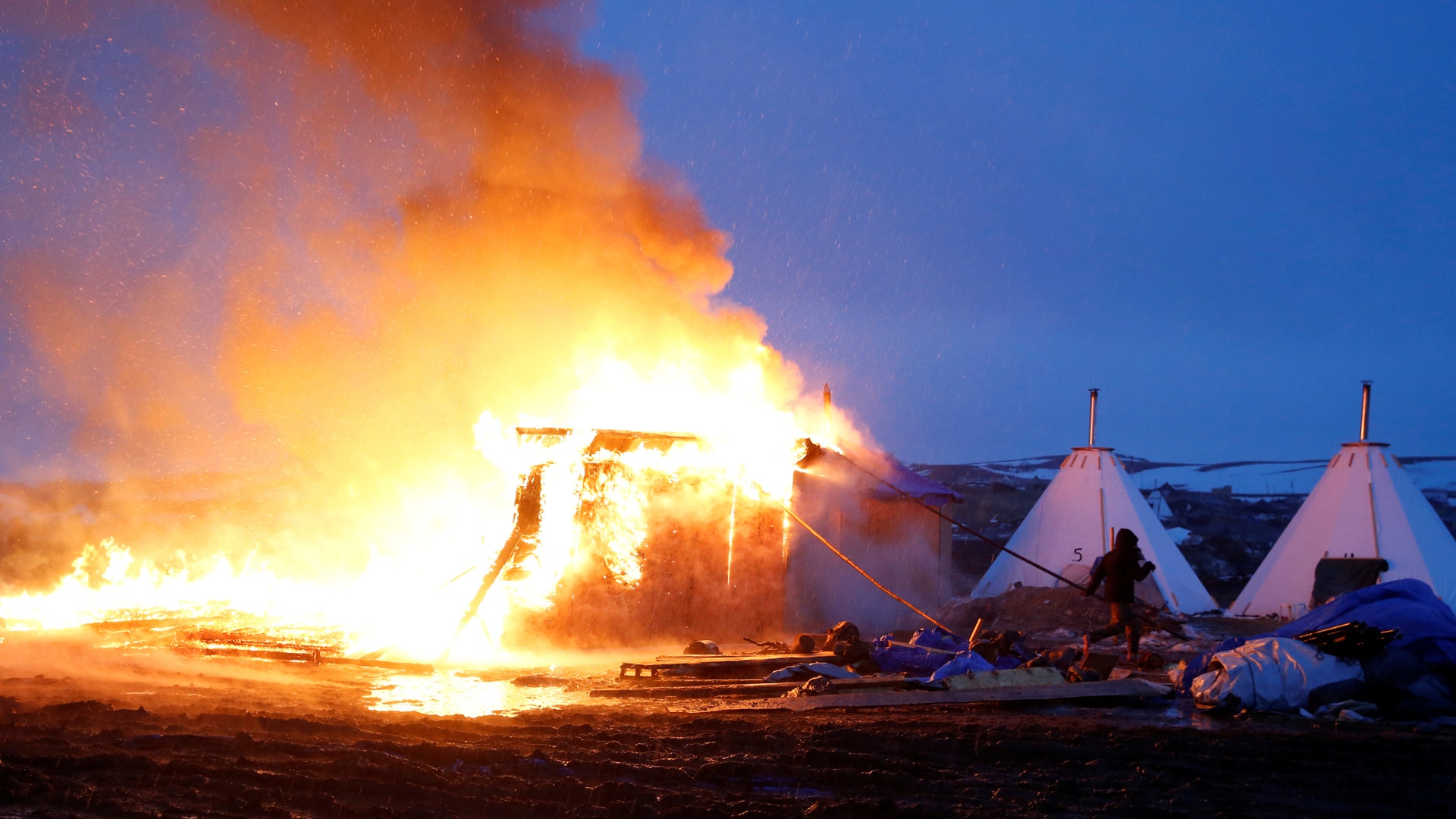 Pipeline protesters set fires ahead of camp closing.