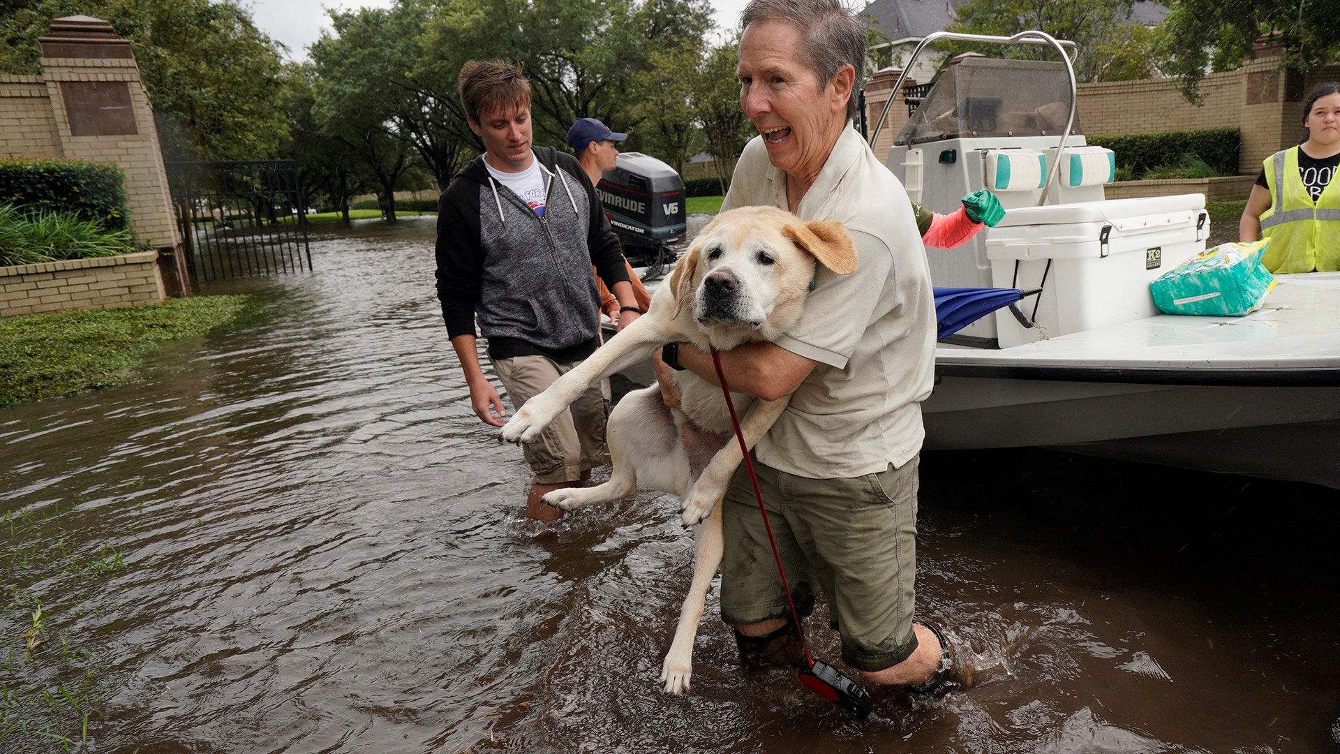 A man is evacuated by boat with his dog from the Hurricane Harvey floodwaters in Houston, Texas, Tuesday