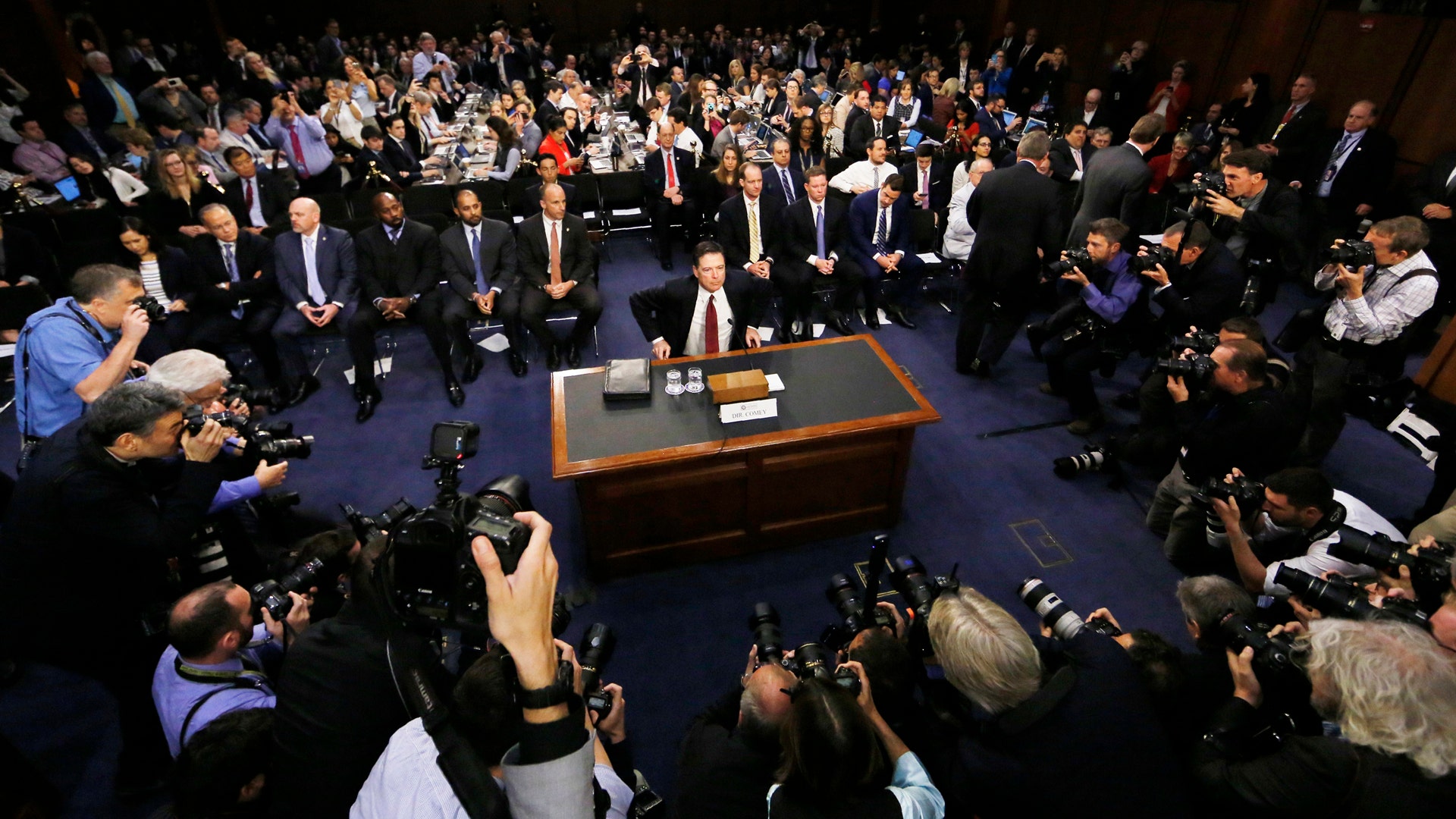 Former FBI Director James Comey takes his seat to testify before a Senate Intelligence Committee hearing