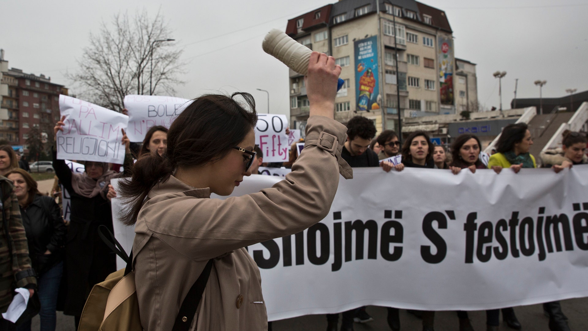 Kosovo feminists hold a sign reading 