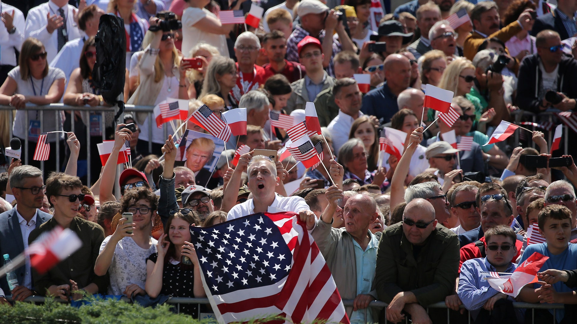People wave Polish and U.S. flags during U.S. President Donald Trump's public speech at Krasinski Square in Warsaw, Poland