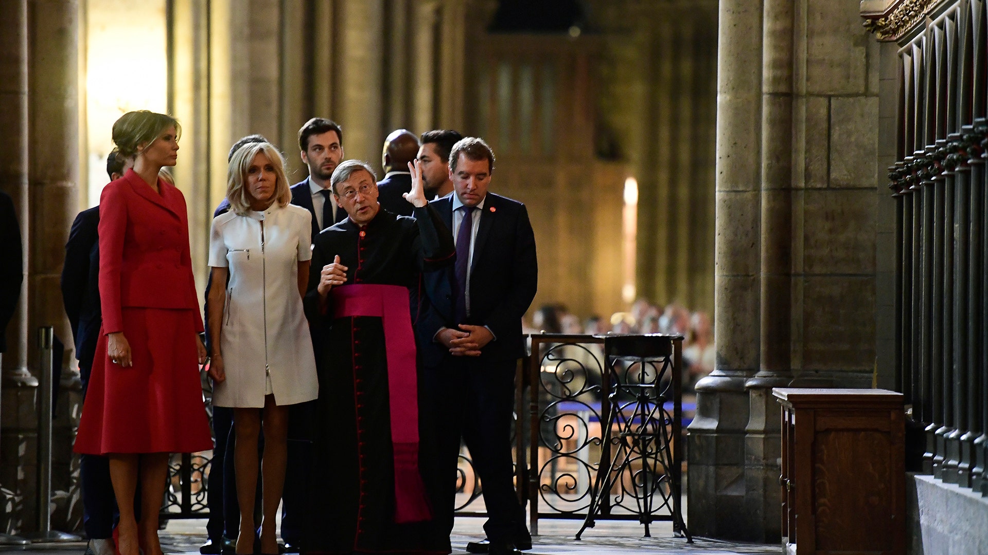 First Lady Melania Trump and French President's wife Brigitte Macron with Notre Dame Cathedral rector Patrick Chauvet in Paris