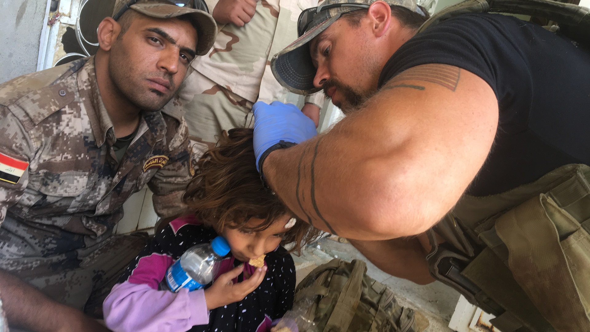 Sky Barkley treats a little girl during the push into Mosul, May 5, 2017