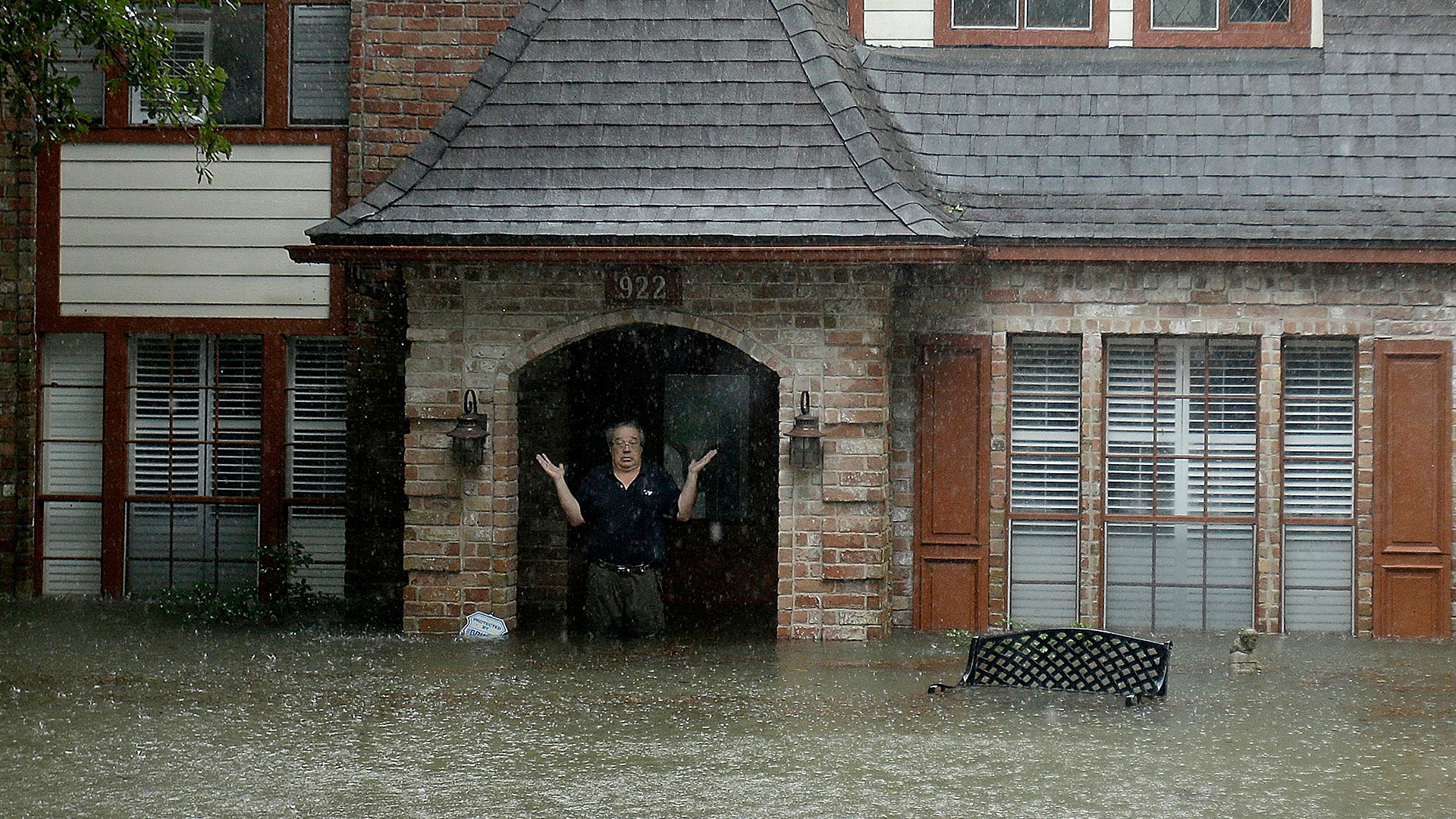 A man standing in the doorway of his flooded home responds to an evacuation offer in Houston, August 28, 2017