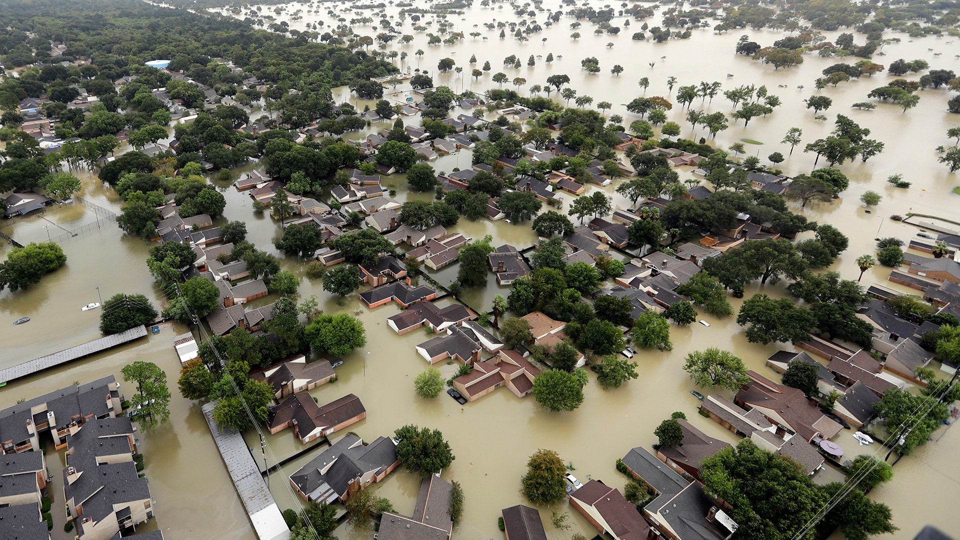 Water from Addicks Reservoir flows into neighborhoods as floodwaters from Tropical Storm Harvey rise Tuesday, in Houston