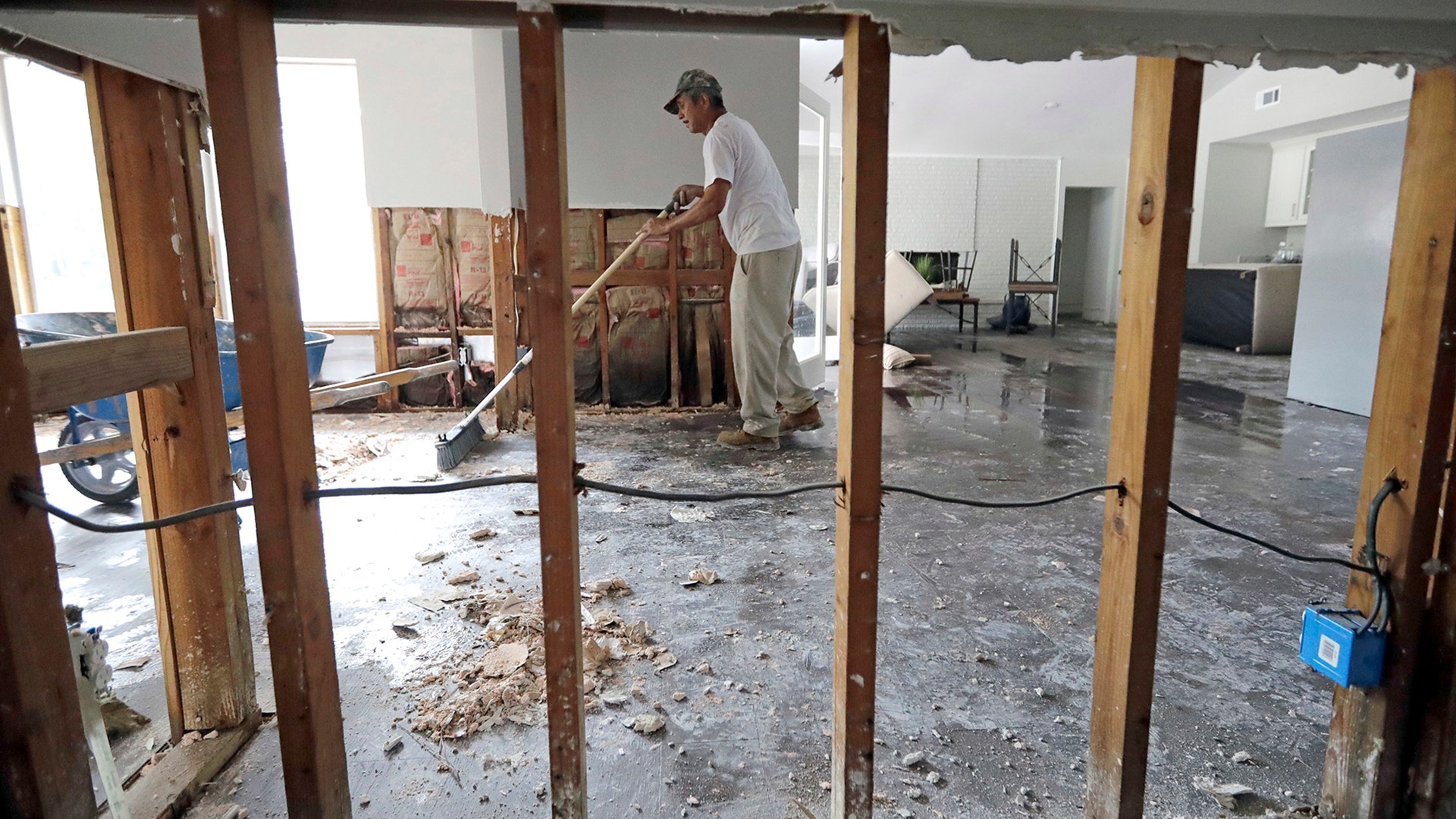 Jose Martinez works to remove drywall from a home damaged by floodwaters from Tropical Storm Harvey in Houston, Wednesday