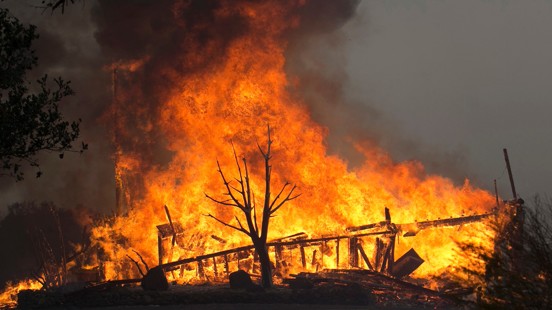 Flames from a wildfire consume a home, Oct. 9, 2017, east of Napa