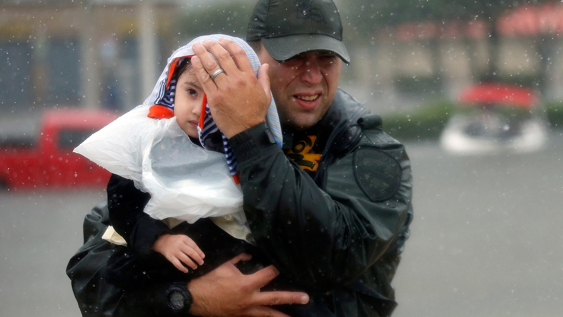 Sgt. Chad Watts, of the Louisiana Department of Wildlife and Fisheries, holds Madelyn Nguyen, 2, after he rescued her in Houston, Monday