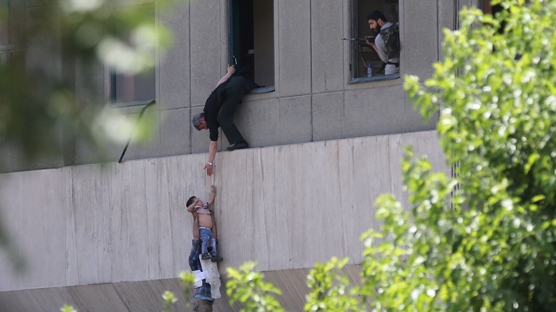A boy is evacuated during an attack on the Iranian parliament in central Tehran, Iran