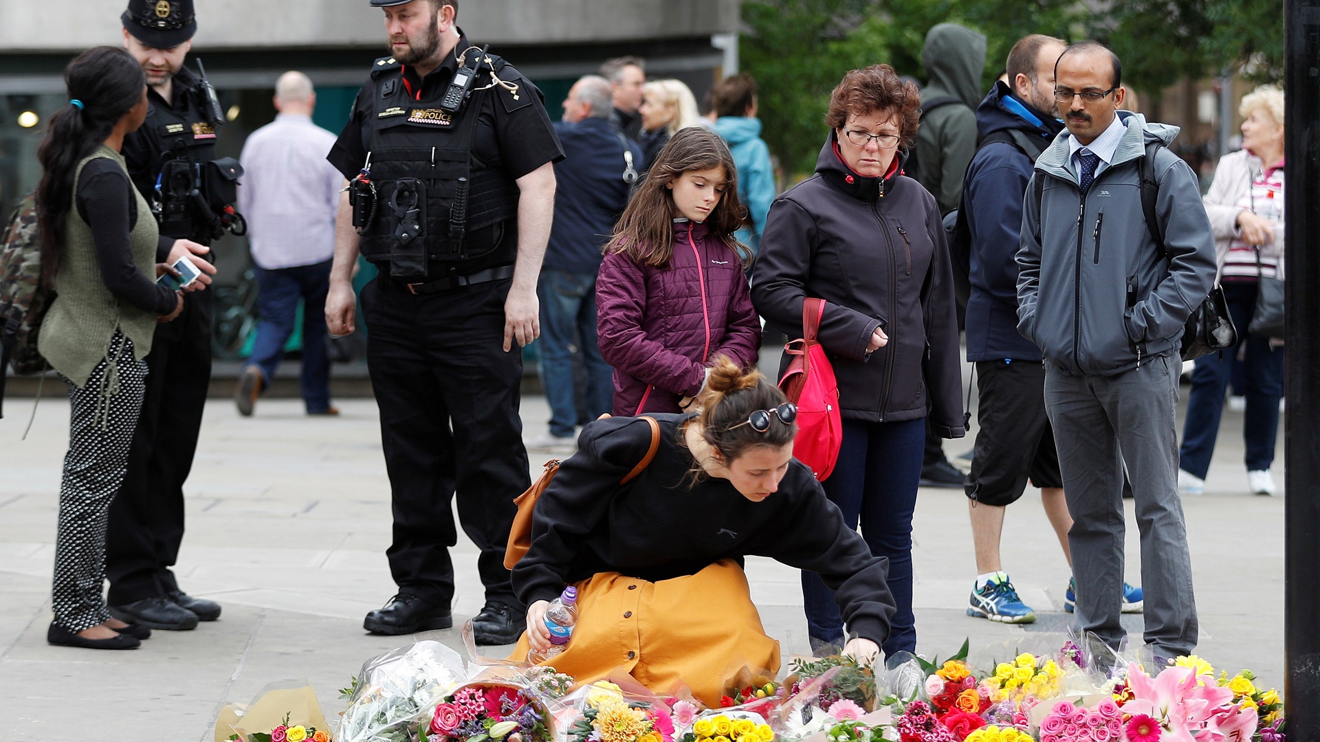 A woman leaves flowers at the south end of London Bridge, near Borough Market