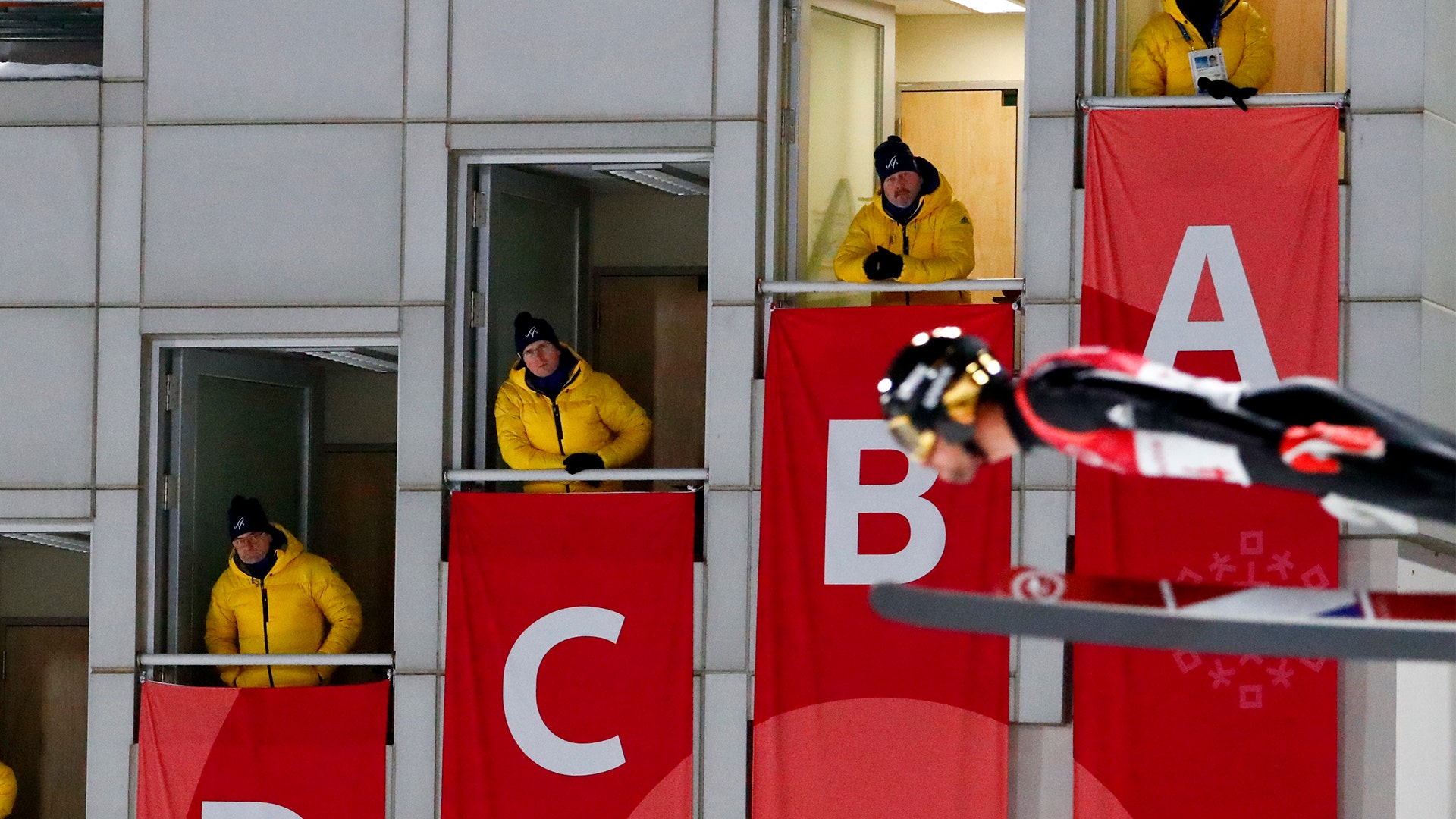 Judges watch as a jumper competes during the men's normal hill individual ski jumping at the 2018 Winter Olympics, February 10