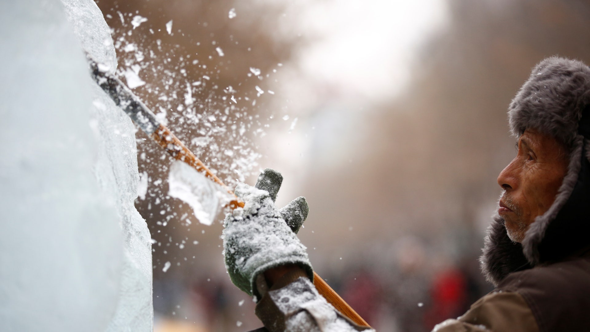An artist polishes an ice sculpture. 