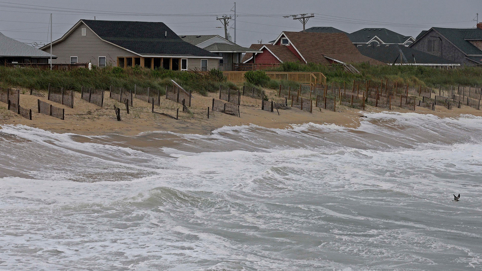 Rising tides move closer to the dunes in Kill Devil Hills, North Carolina, Thursday