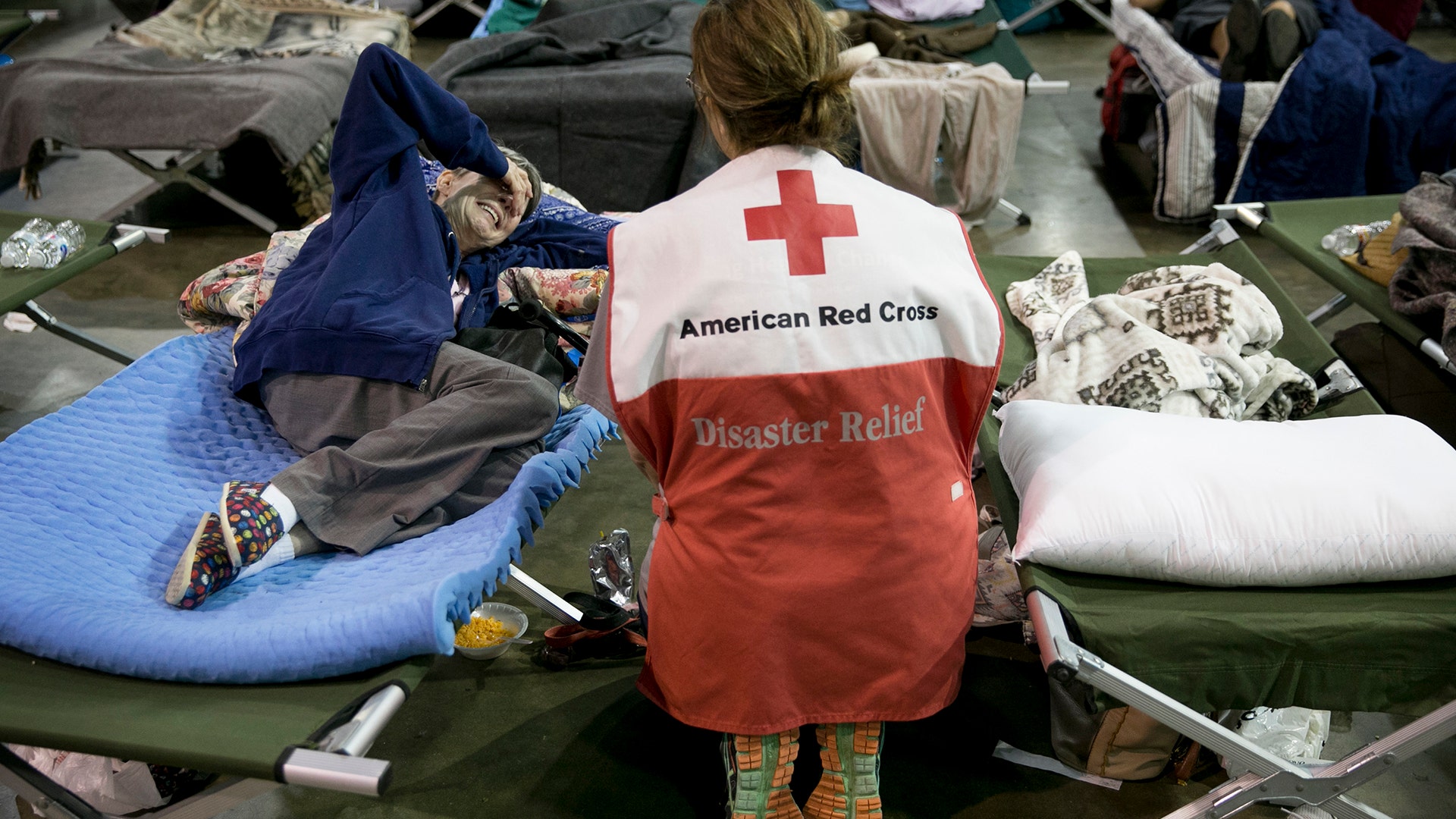 Volunteer Lisa Black comforts Janice Forse at the emergency shelter at the Beaumont Civic Center in Beaumont, Texas, Wednesday