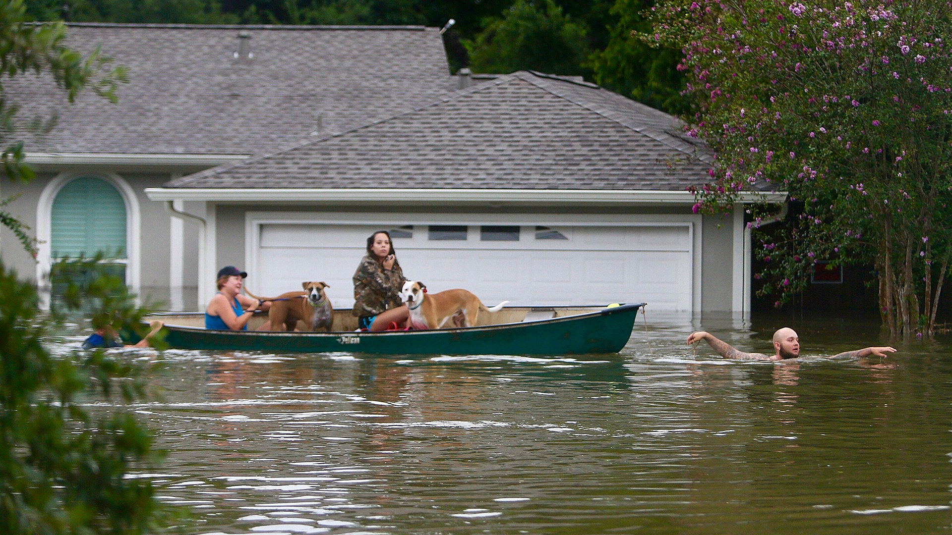 A family evacuates their Meyerland home in Houston, Texas, Sunday