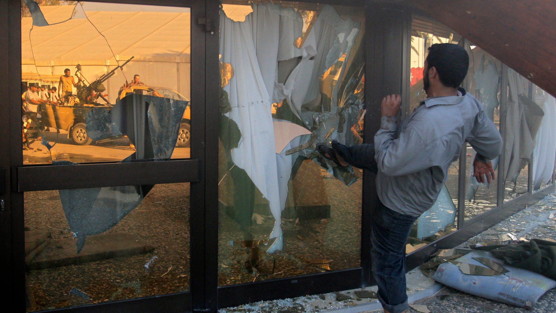 Rebel_Fighter_Kicks_Qaddafi_Glass_Compound_Window