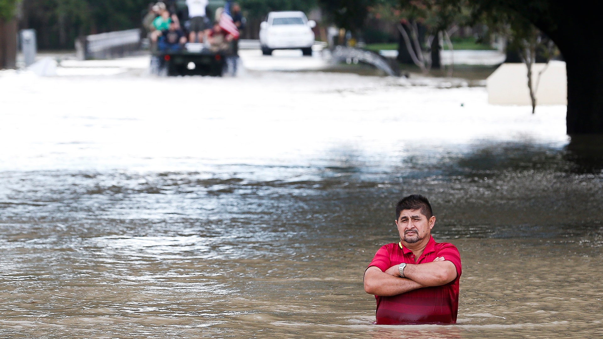 A man stands in deep flood water along West Little York Road in Houston, Tuesday