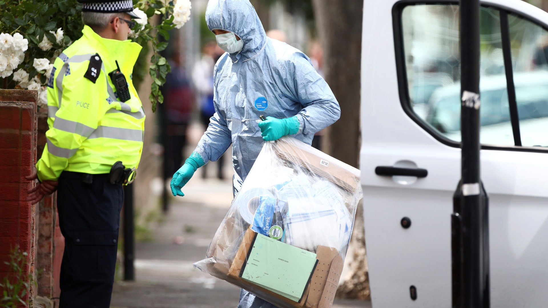 Forensics investigators work at a property which was raided by police in East Ham, east London