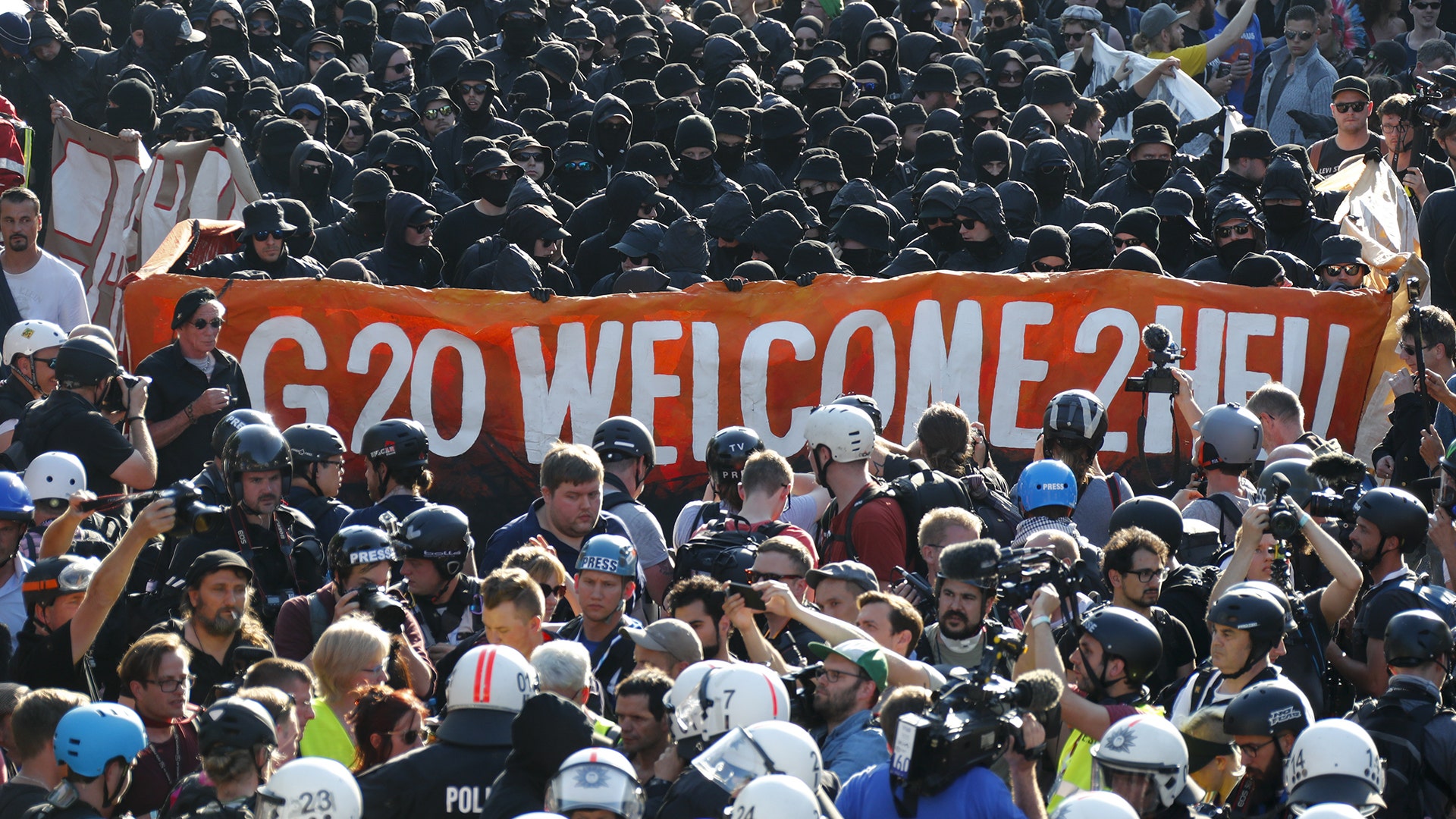 German riot police stand in front of protesters during demonstrations at the G-20 summit in Hamburg, Germany, July 6