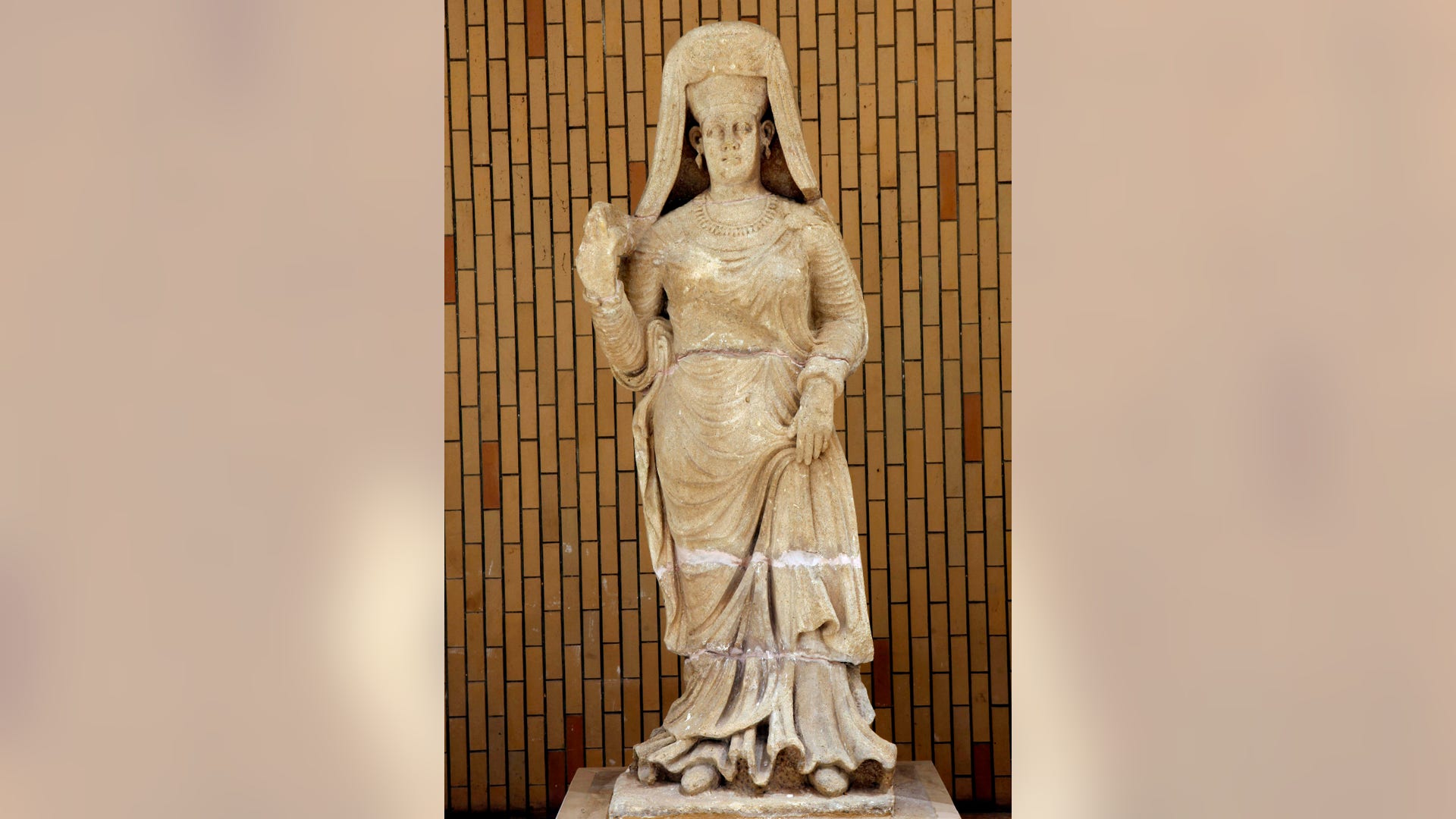 A limestone statue of a woman dressed with a cloak, found at Hatra