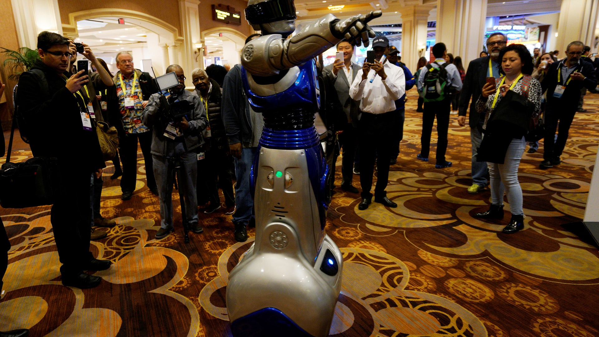 A man in a mechanized robotic costume points the way for showgoers to the CES Unveiled event at CES in Las Vegas.