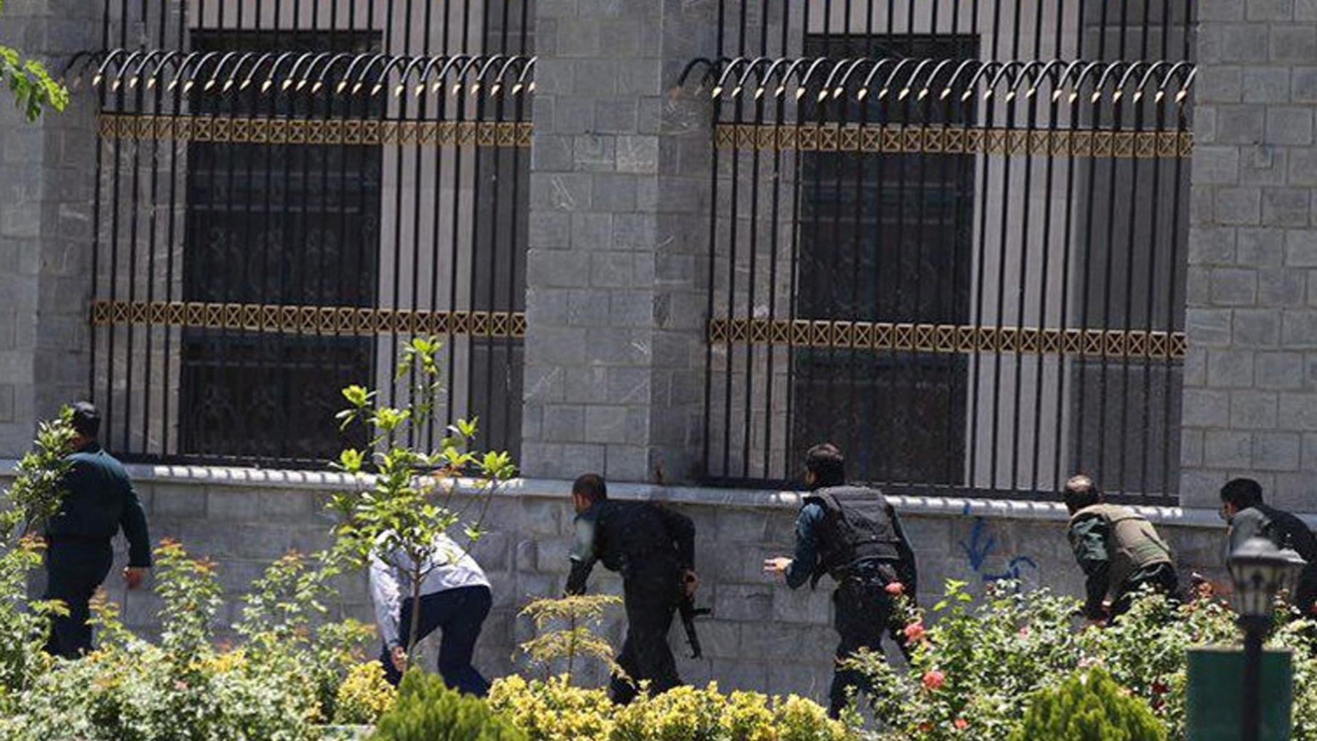 Members of Iranian forces run during an attack on the Iranian parliament
