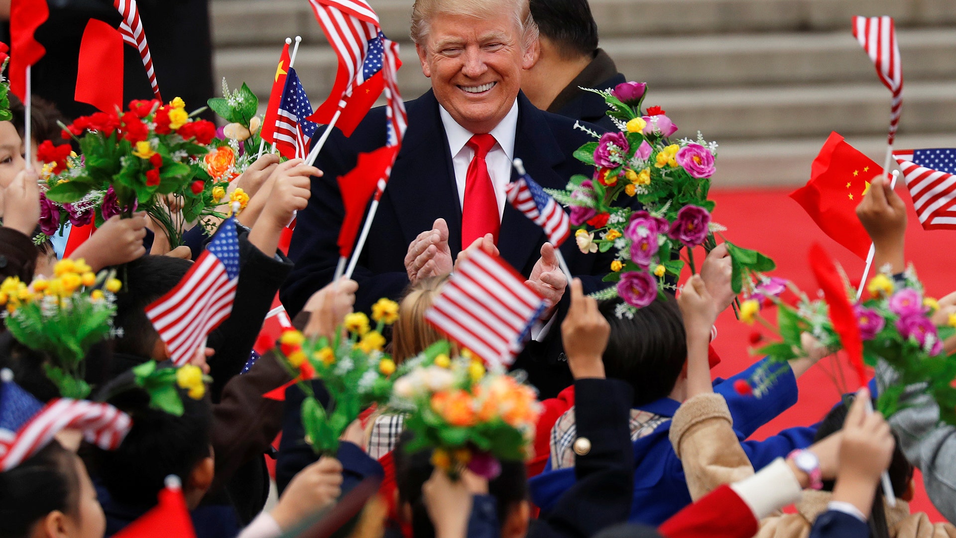 President Donald Trump and China's President Xi Jinping greet people in Beijing, China, Thursday