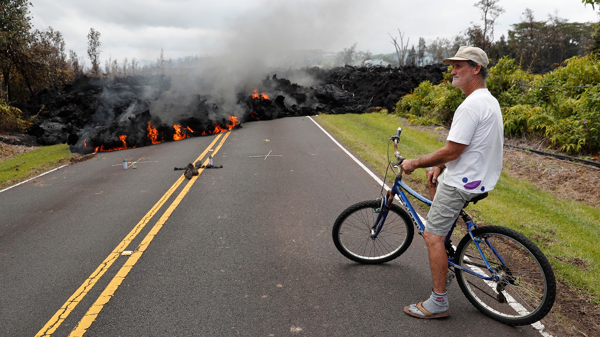 Leilani Estates resident Sam Knox watches the lava stretch across the road, in Pahoa, Hawaii, May 5, 2018,