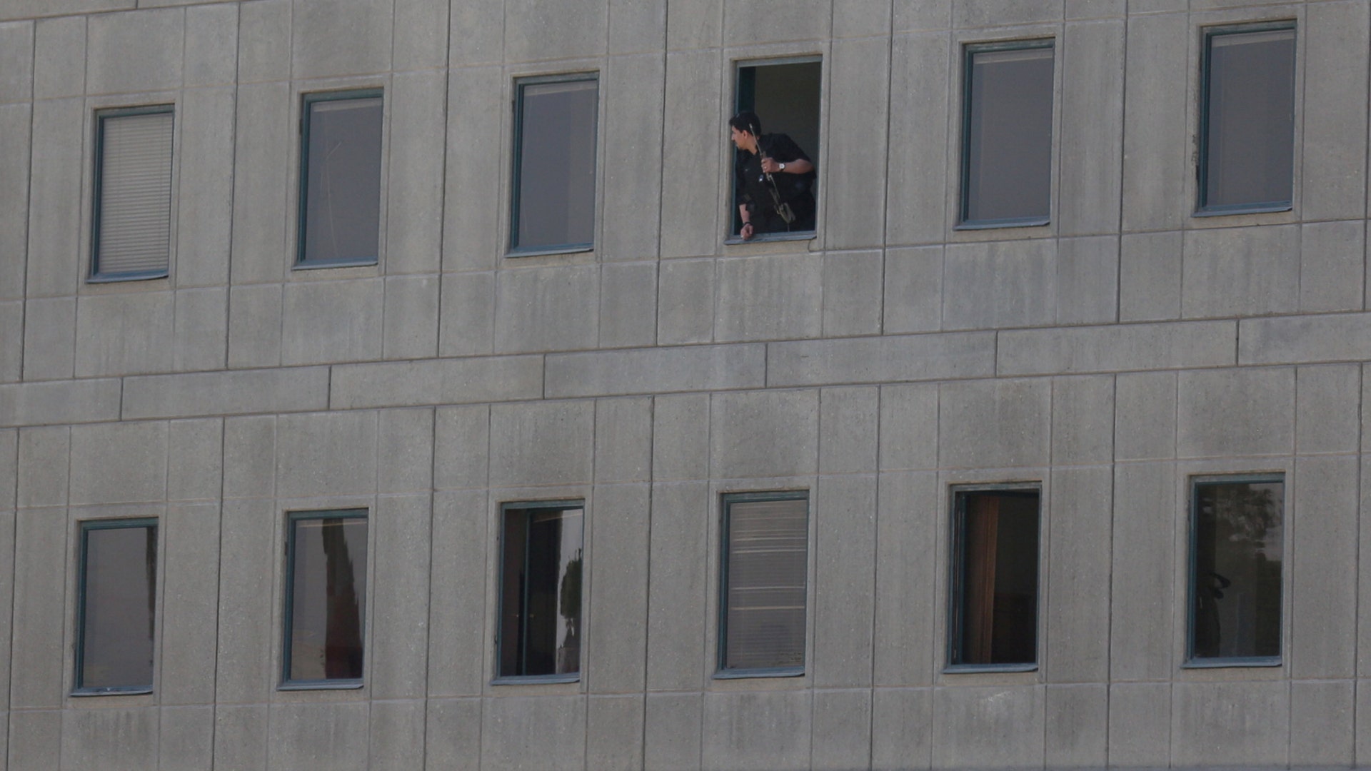 An Iranian policeman looks out of the parliament's building