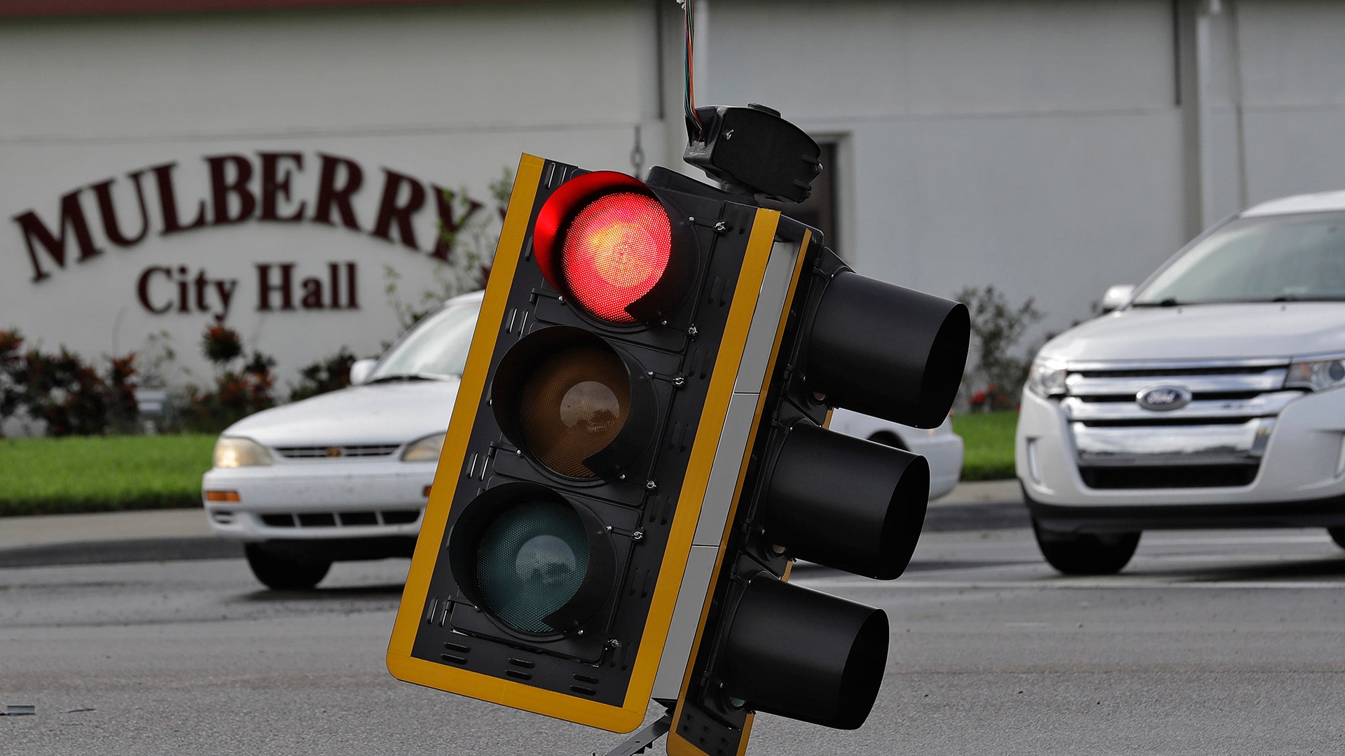 Motorists drive around a downed traffic light from winds from Hurricane Irma Monday, in Mulberry, Fla
