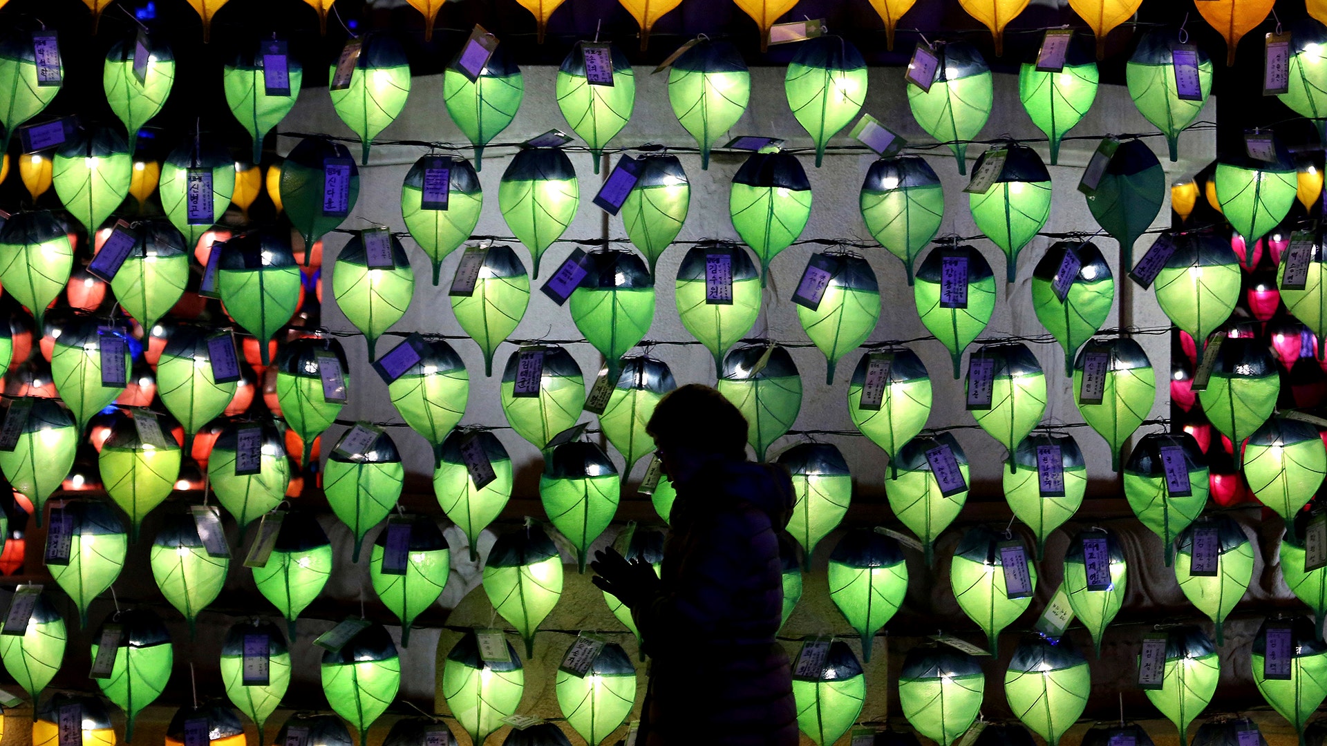 A woman prays in front of lanterns to celebrate the New Year at Jogyesa Buddhist temple in Seoul, South Korea