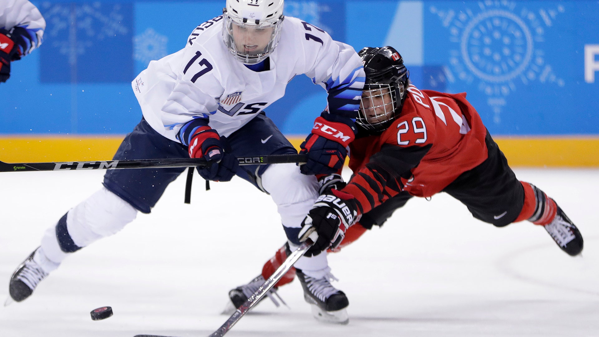 Jocelyne Lamoureux-Davidson of the United States and Marie-Philip Poulin of Canada compete for the puck at the Winter Olympics