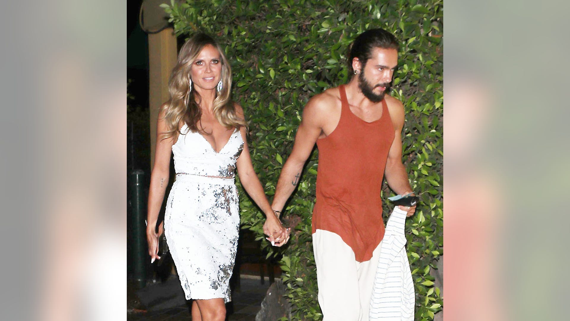 Wednesday, August 22, 2018 - Heidi Klum is striking in her white gown, holding hands with beau Tom Kaulitz as they attend Simon Cowell's America's Got Talent after party at AGO restaurant in West Hollywood. 