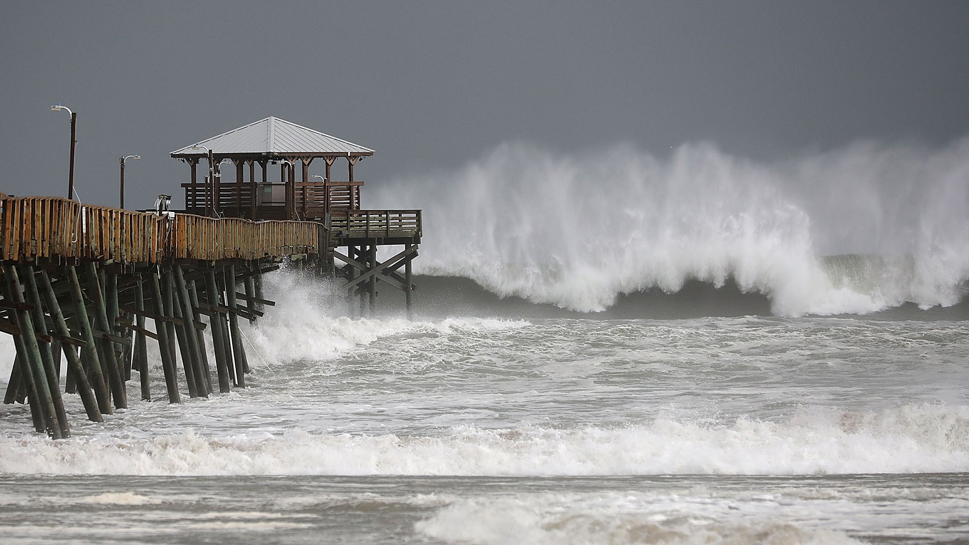 Waves crash around the Oceana Pier as the outer edges of Hurricane Florence being to affect Atlantic Beach, North Carolina, Thursday
