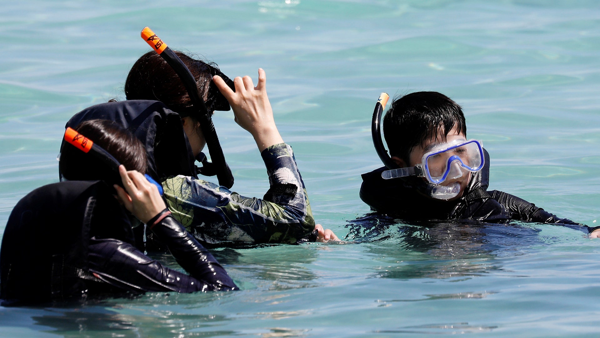 Tourists snorkel on the waters off Tumon beach, August 11, 2017.  