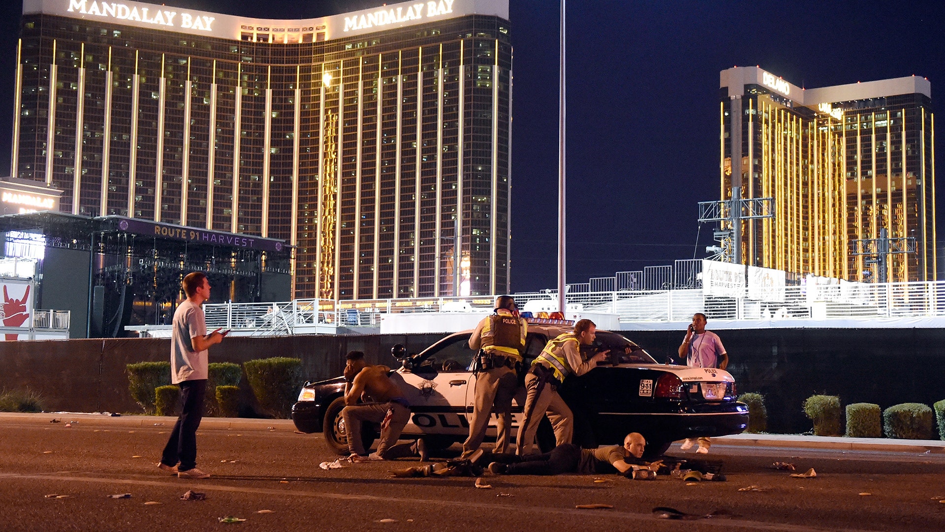 Las Vegas police stand guard along the streets outside the Route 91 Harvest Country music festival grounds, Sunday, in Las Vegas