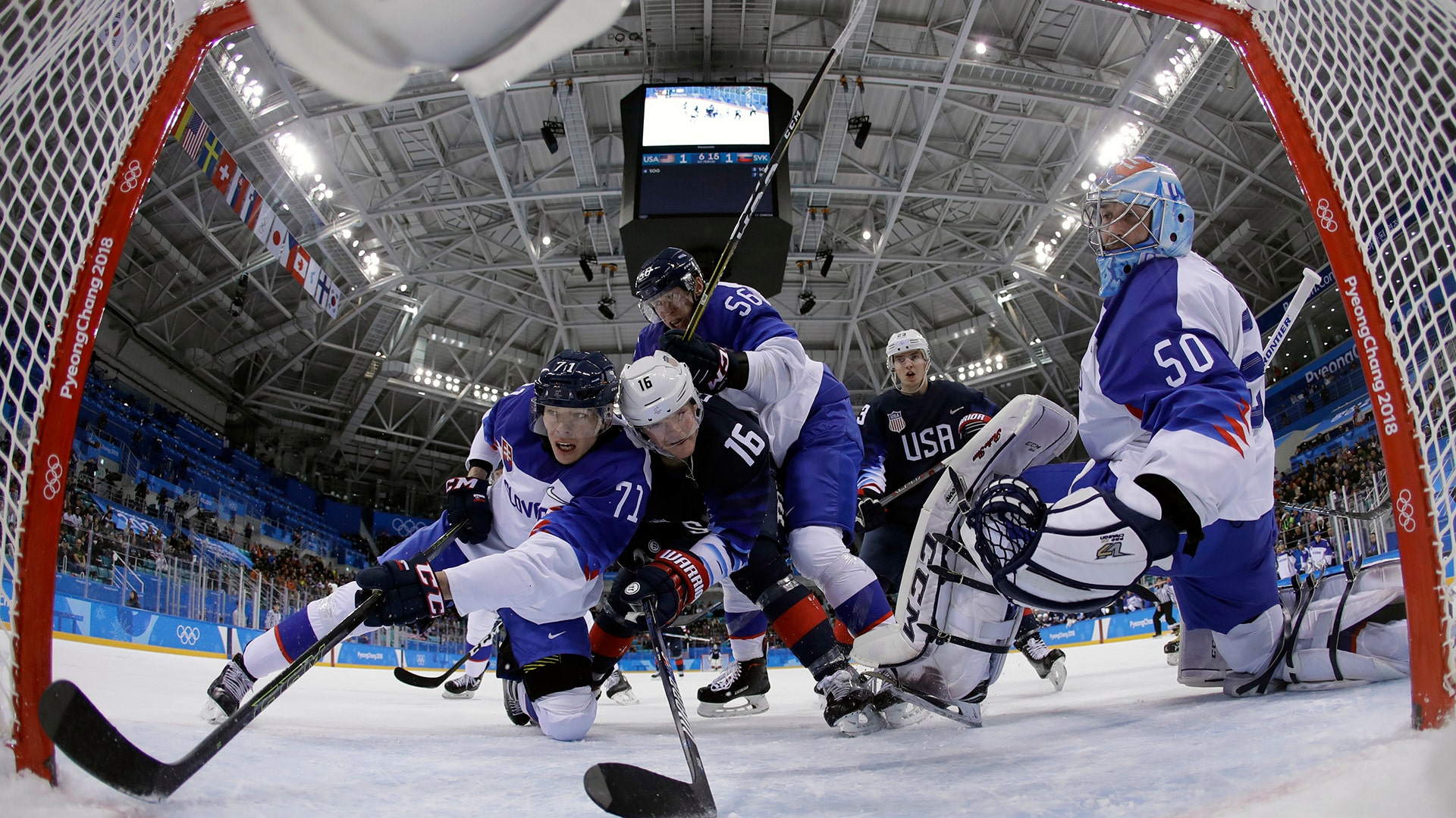 Ryan Donato of the U.S. battles for the puck against Slovakia's Marek Daloga and Michal Cajkovsky of Slovakia at the Winter Olympics