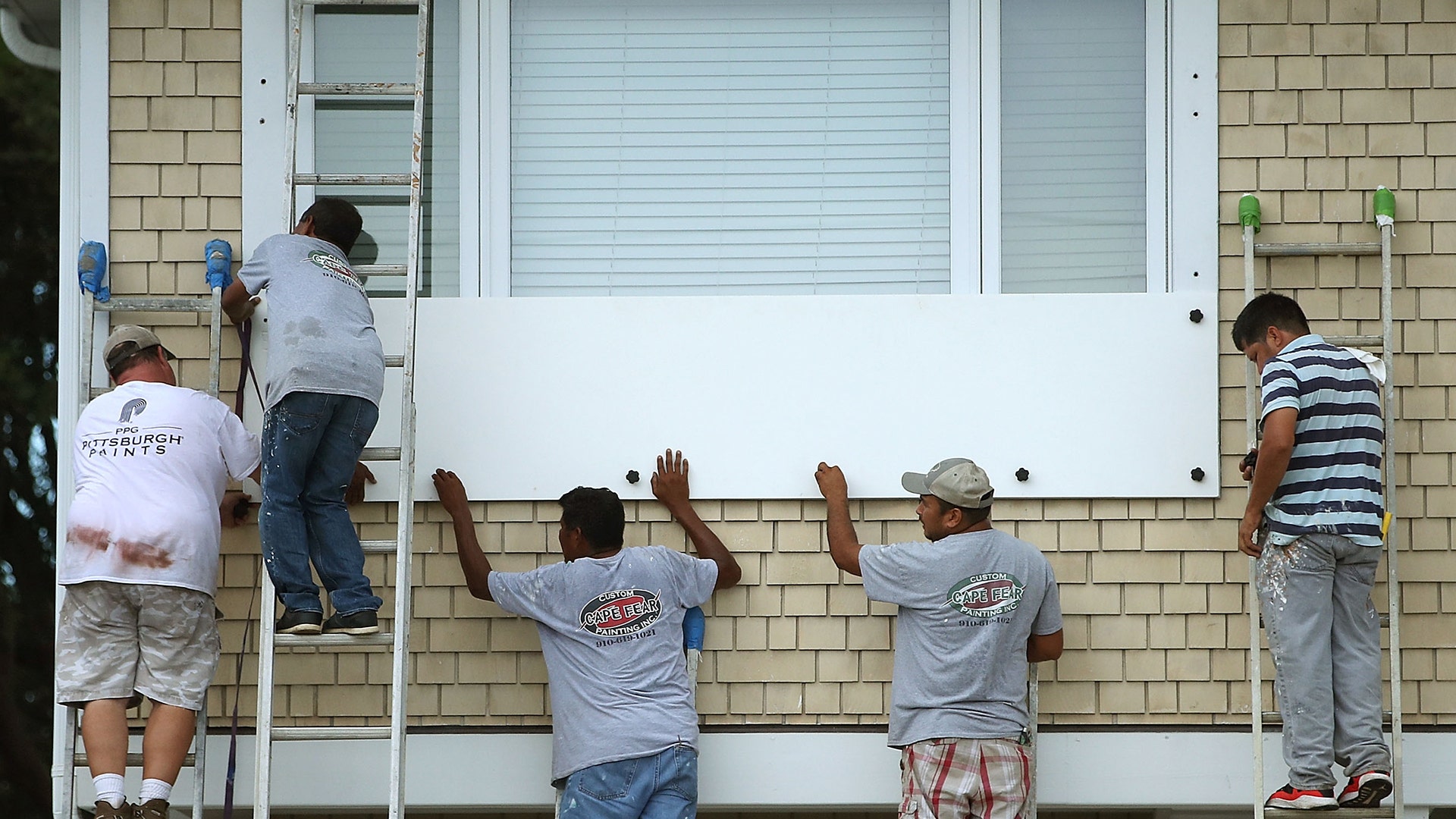 Workers board up a home while preparing for the arrival of Hurricane Florence in Wrightsville Beach, North Carolina, Tuesday