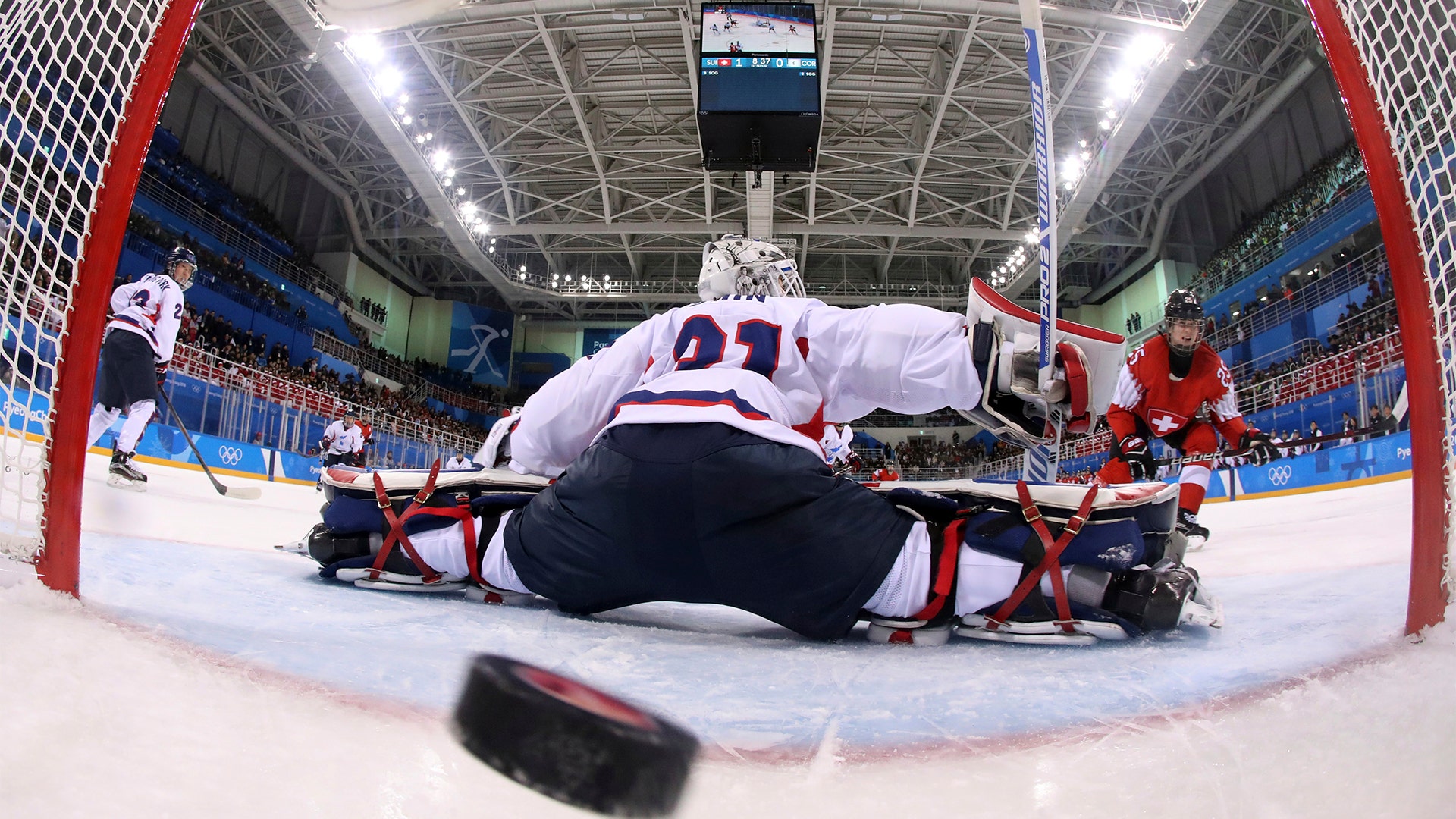 Alina Muller of Switzerland scores a goal against South Korea's goalie Shin So-jun