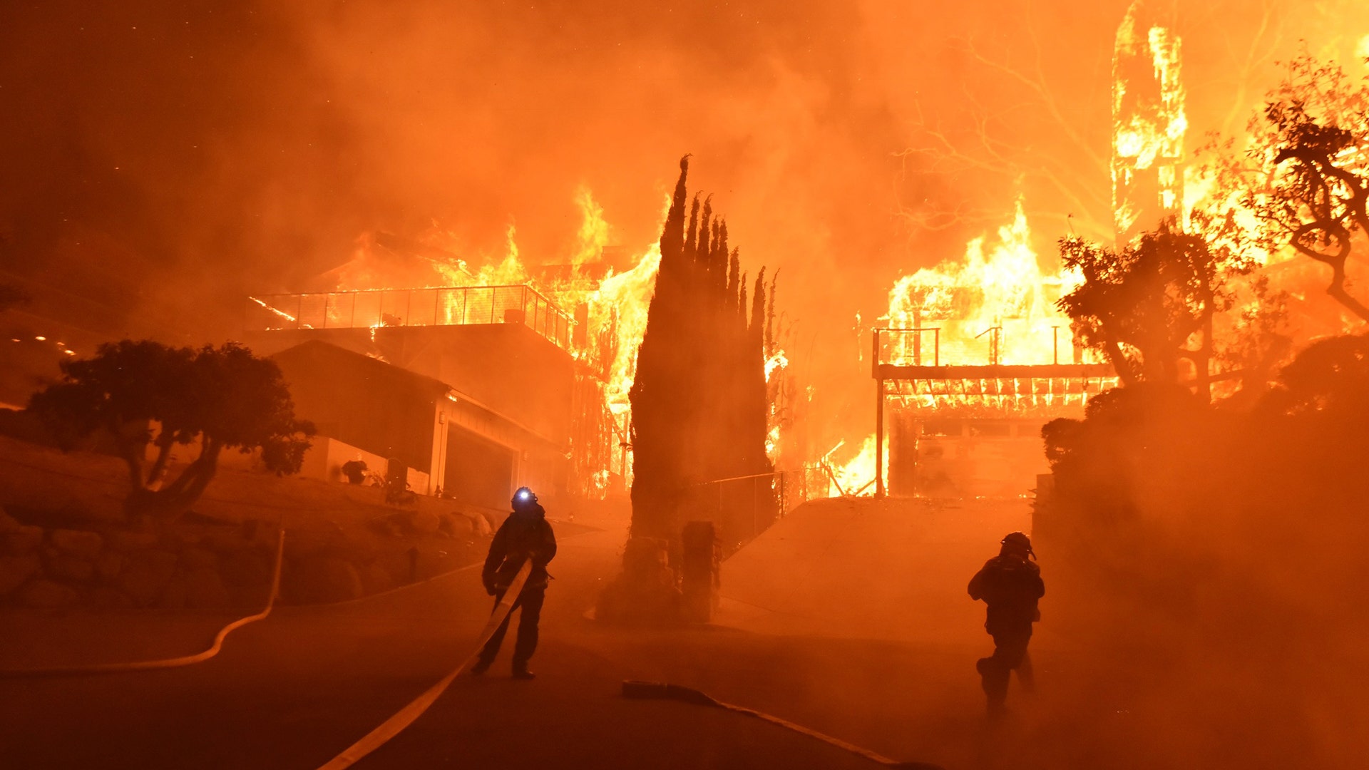 Firefighters work to put out a blaze burning homes early Tuesday in Ventura, California