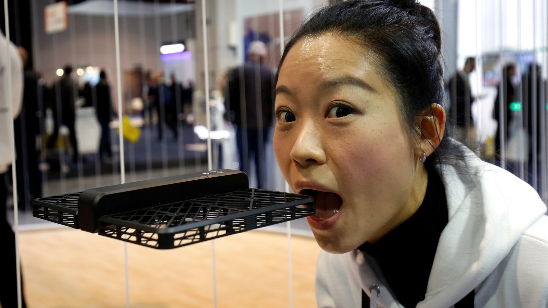 Xiao Huang of Zero Zero Robotics demonstrates the safety of the company's Hover Camera Passport drone by pretending to bite it during the 2017 CES in Las Vegas, Nevada.