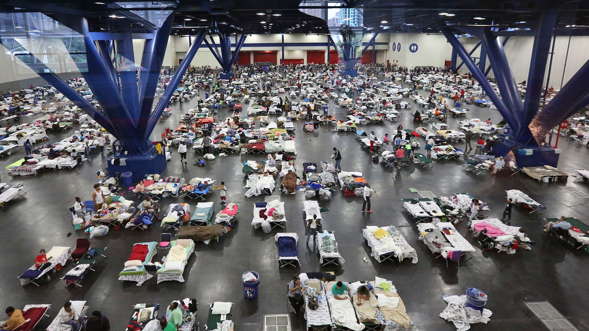 Evacuees escaping the floodwaters from Tropical Storm Harvey rest at the George R. Brown Convention Center in Houston, Tuesday