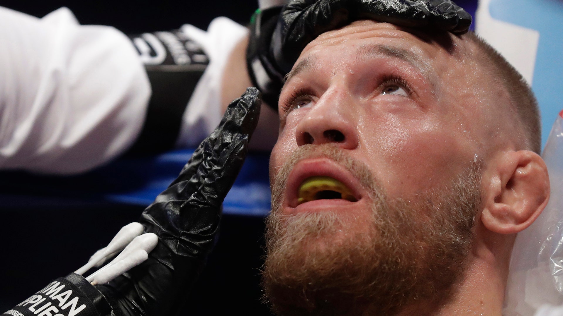 Conor McGregor sits in his corner between rounds in a super welterweight boxing match against Floyd Mayweather Jr.