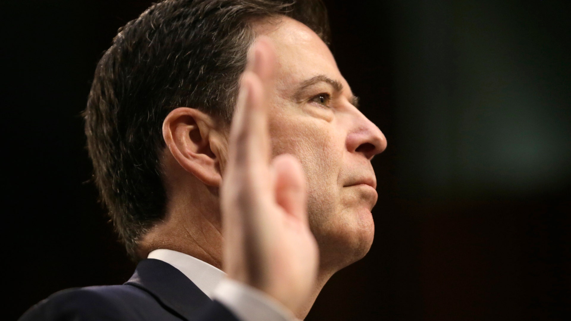 Former FBI Director James Comey is sworn in before testifying before a Senate Intelligence Committee hearing