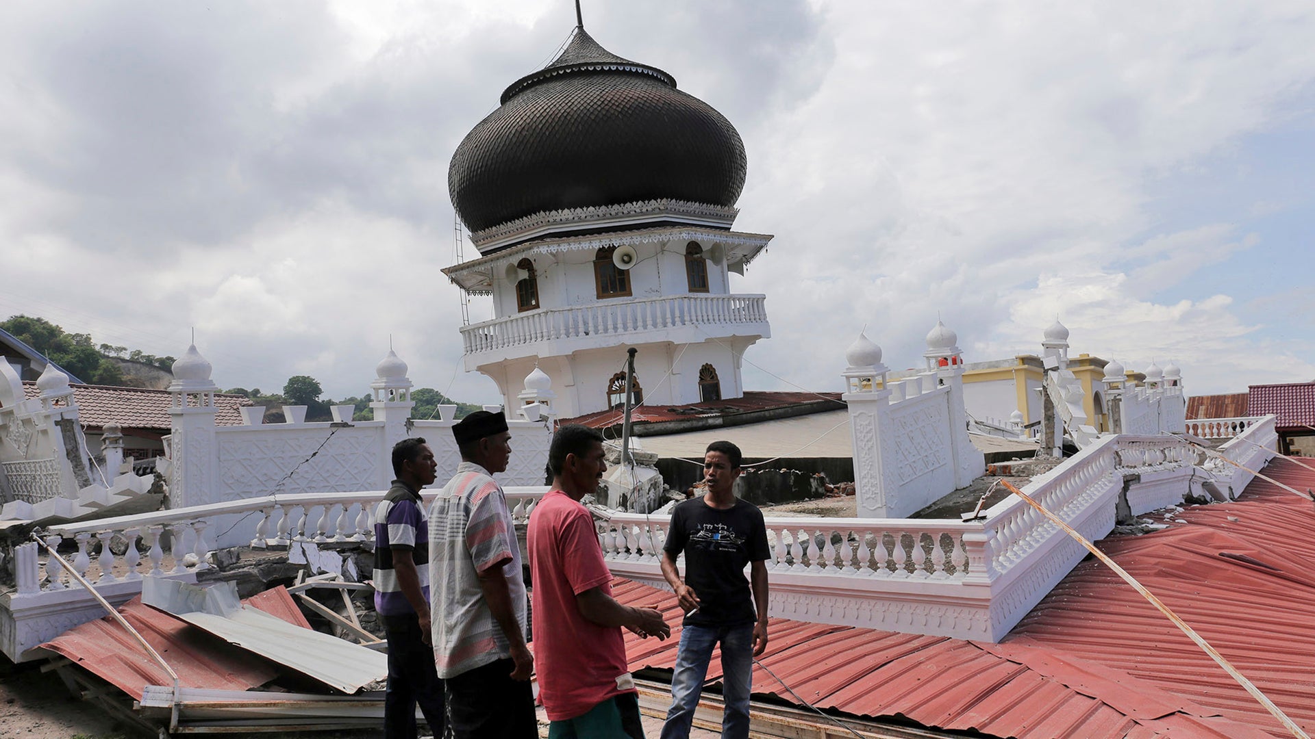 Men inspect a collapsed mosque after an earthquake in Pidie Jaya, Aceh province, Indonesia.